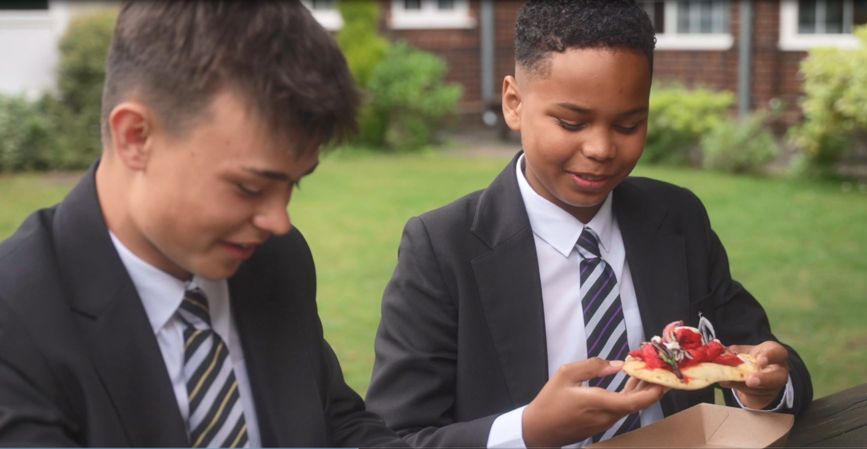 Two boys eating a pie