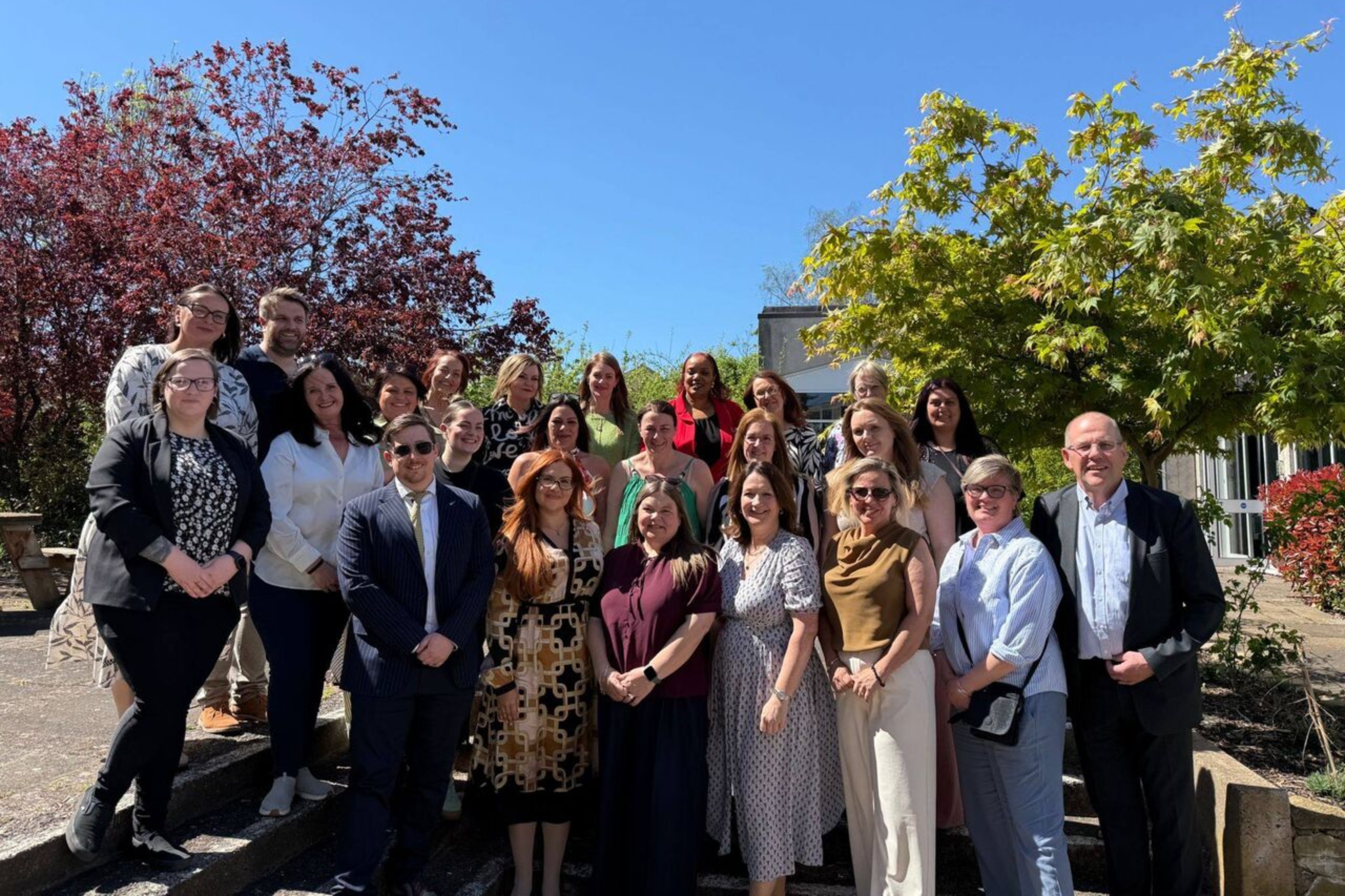 The AiP Team standing together outside, dressed in formalwear for the Spirit of Sodexo Awards.